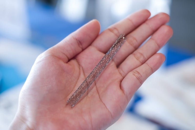 metal peripheral vascular stent on hand_